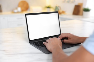 Photo of Man using laptop at white marble table indoors, closeup