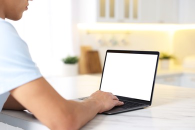 Photo of Man using laptop at white marble table indoors, closeup