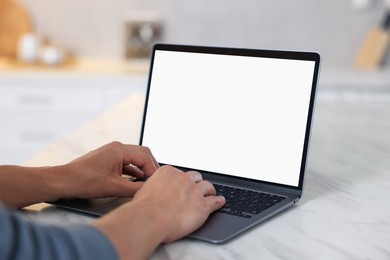 Photo of Man using laptop at white marble table indoors, closeup