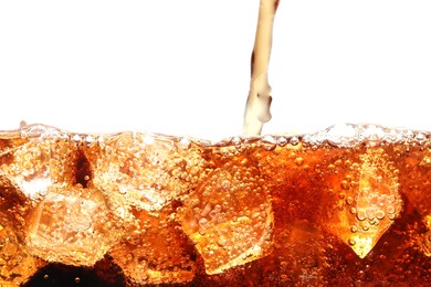 Photo of Pouring refreshing cola into glass with ice isolated on white