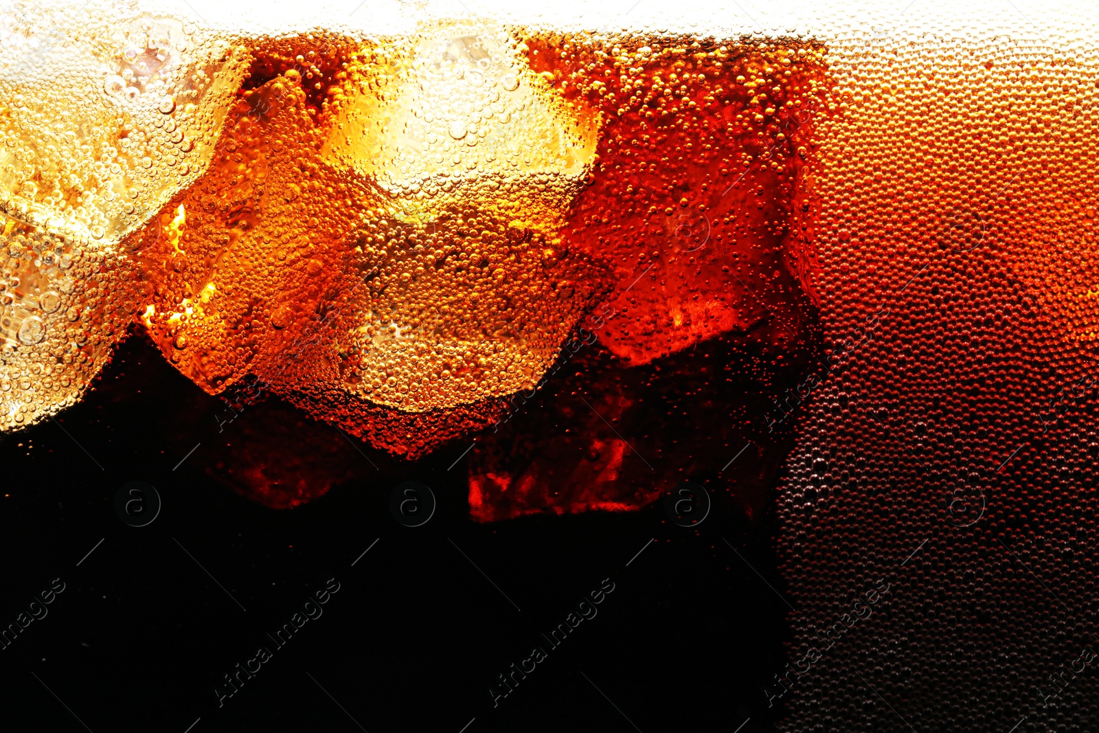 Fizzy cola with ice as background, macro view Photo of Fizzy cola with ice as background, macro view