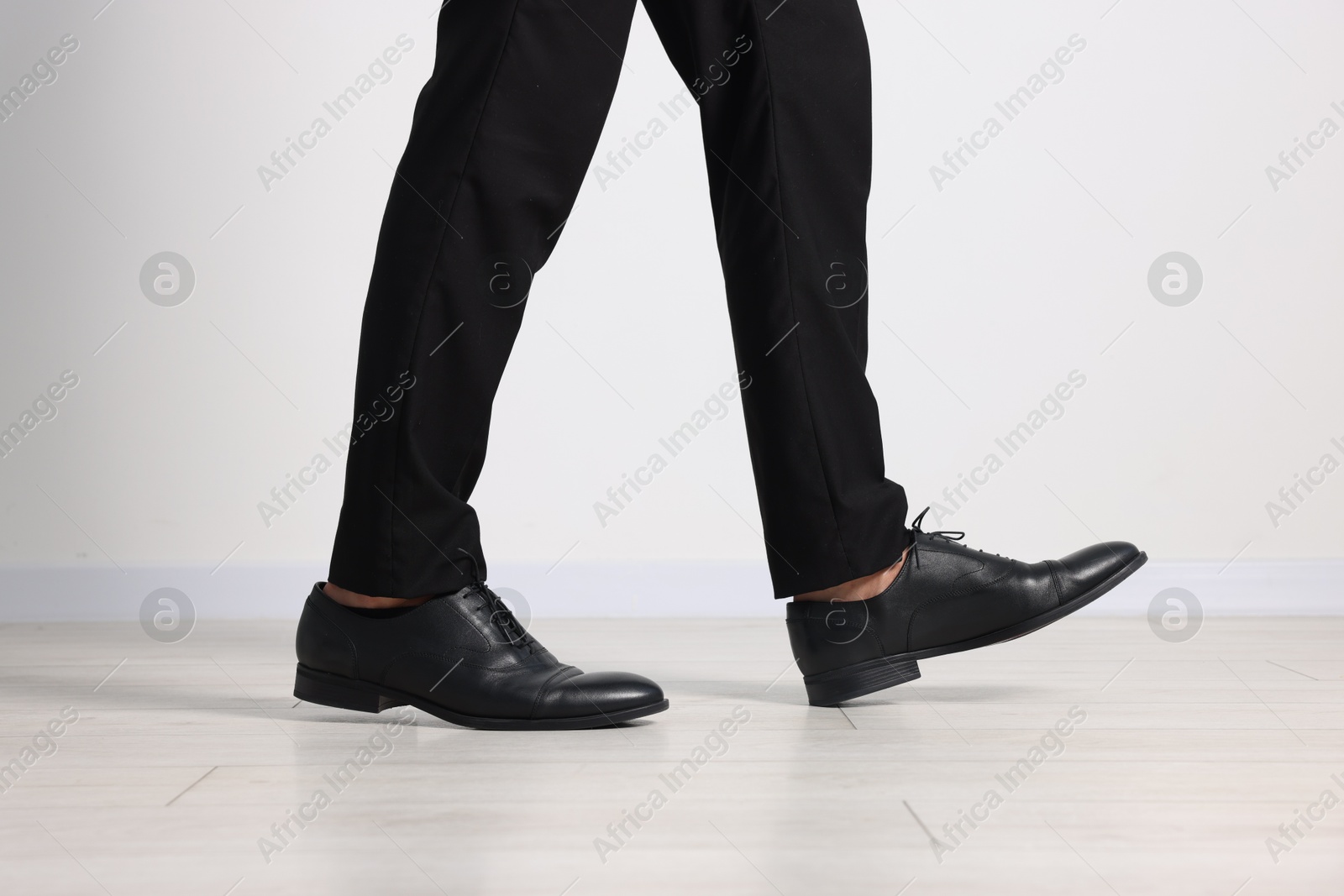 Photo of Man wearing pair of black leather shoes indoors, closeup