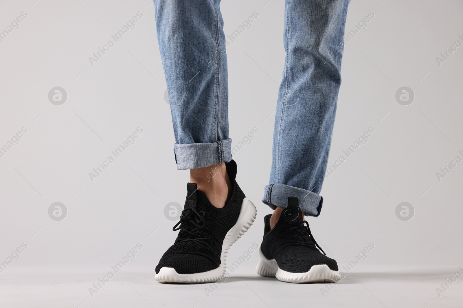 Man wearing pair of black sneakers indoors, closeup Photo of Man wearing pair of black sneakers indoors, closeup