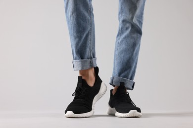 Photo of Man wearing pair of black sneakers indoors, closeup