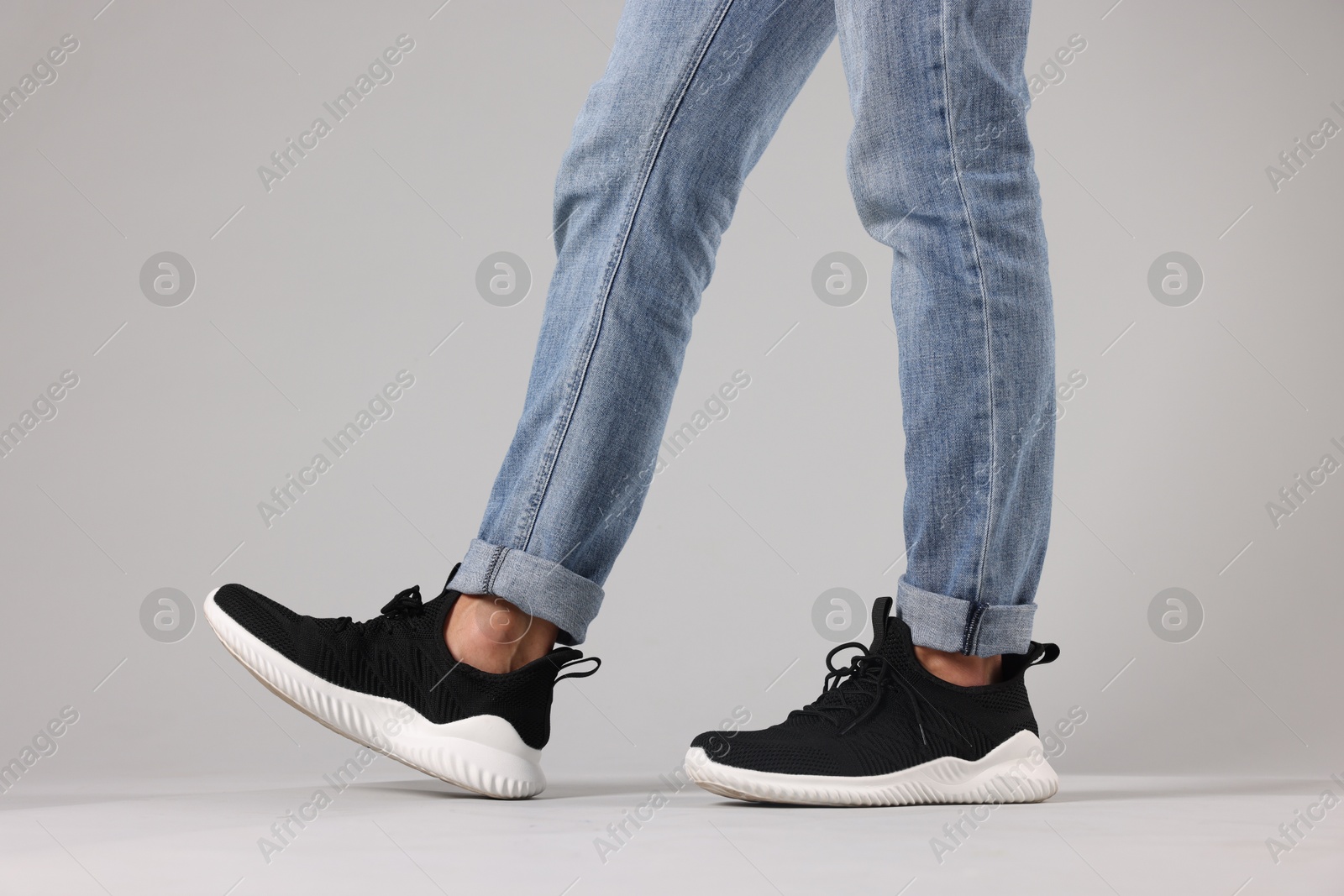 Man wearing pair of black sneakers indoors, closeup Photo of Man wearing pair of black sneakers indoors, closeup