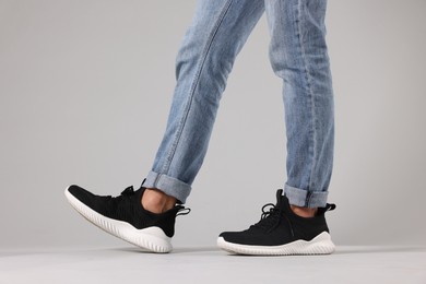 Photo of Man wearing pair of black sneakers indoors, closeup