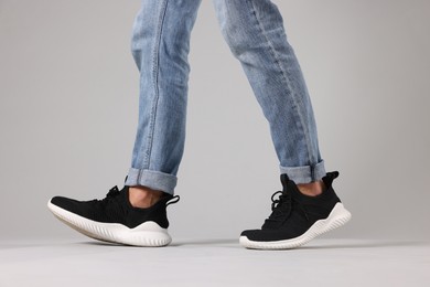 Photo of Man wearing pair of black sneakers indoors, closeup