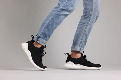 Photo of Man wearing pair of black sneakers indoors, closeup