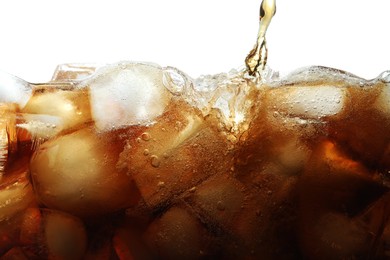 Photo of Pouring refreshing cola into glass with ice isolated on white