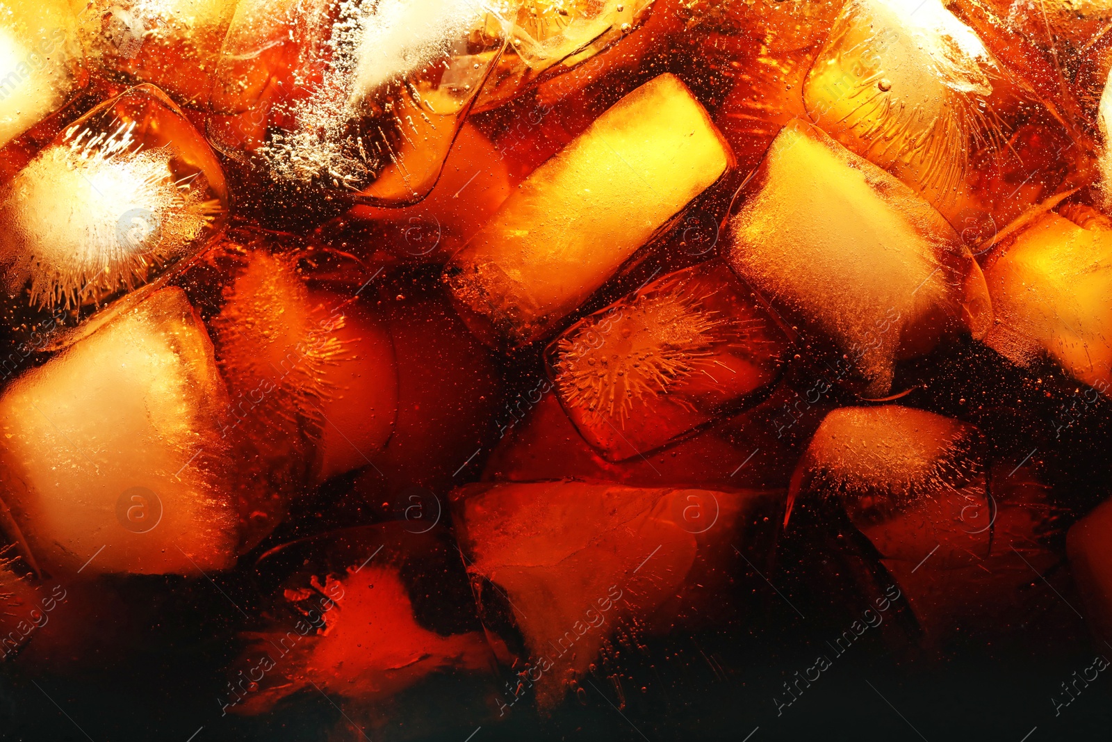 Refreshing cola with ice as background, macro view Photo of Refreshing cola with ice as background, macro view