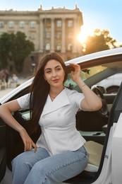 Photo of Woman getting out of modern car outdoors