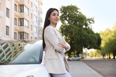 Photo of Beautiful woman near white car on city street