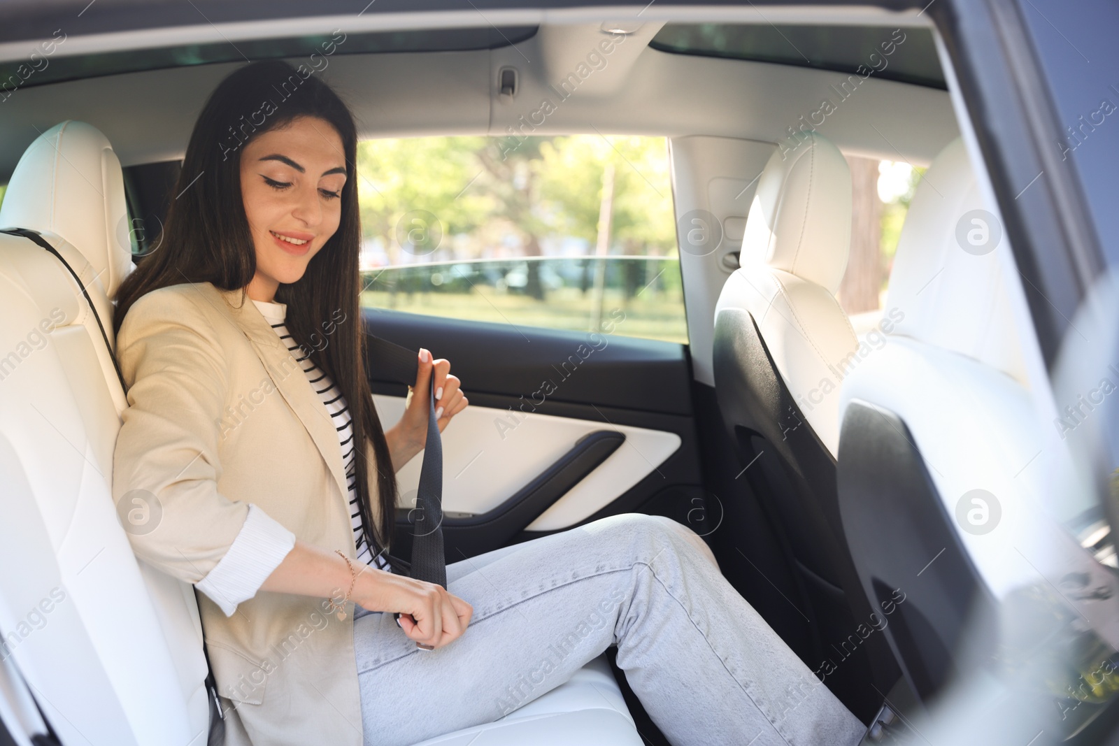 Woman fastening seat belt in modern car, view from outside Photo of Woman fastening seat belt in modern car, view from outside