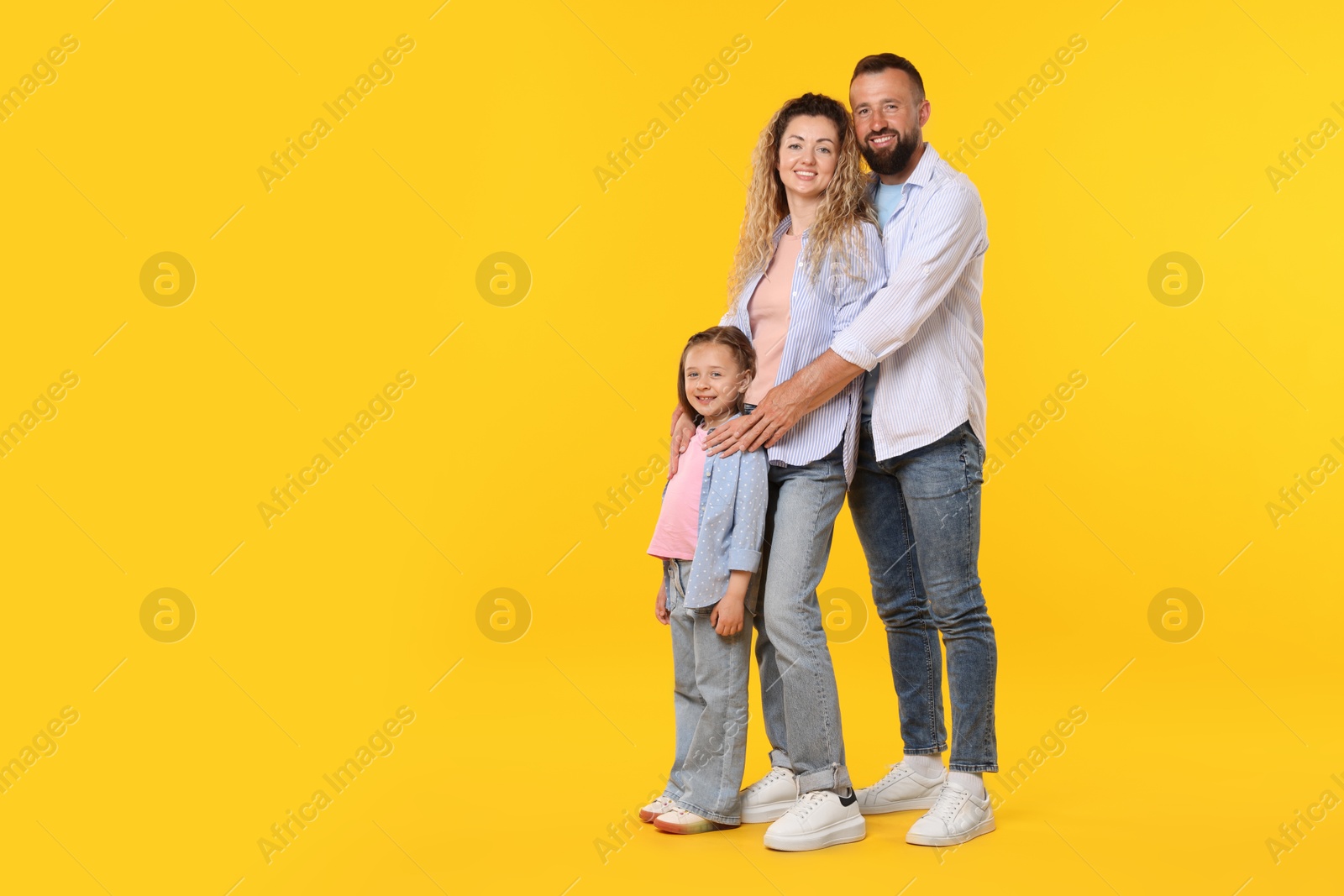 Happy family on yellow background. Space for text Photo of Happy family on yellow background. Space for text