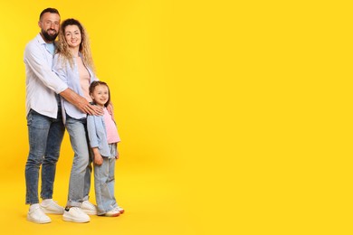 Photo of Happy family on yellow background. Space for text