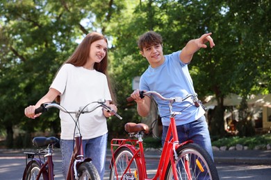 Photo of Teenage girl and boy with bicycles on city street
