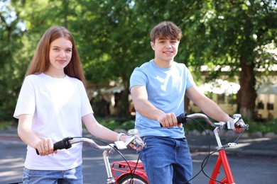 Photo of Teenage girl and boy riding bicycles on city street