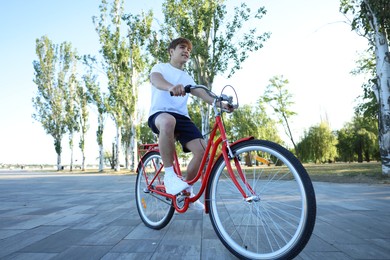 Photo of Teenage boy riding bicycle on city street