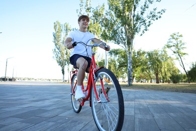 Photo of Teenage boy riding bicycle on city street, space for text