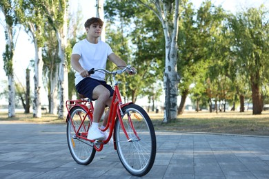 Photo of Teenage boy riding bicycle on city street, space for text