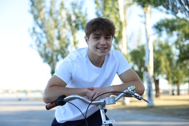 Photo of Teenage boy riding bicycle on city street