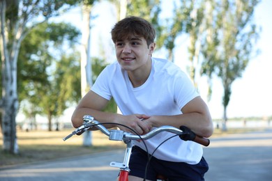 Photo of Teenage boy riding bicycle on city street