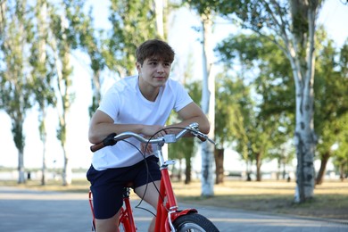 Photo of Teenage boy riding bicycle on city street