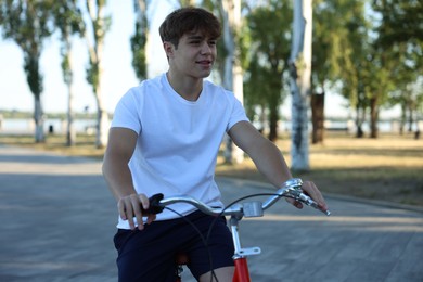 Photo of Teenage boy riding bicycle on city street