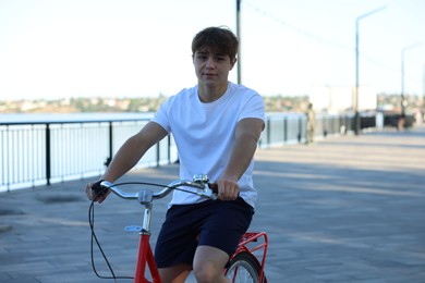 Photo of Teenage boy riding bicycle on city street, space for text