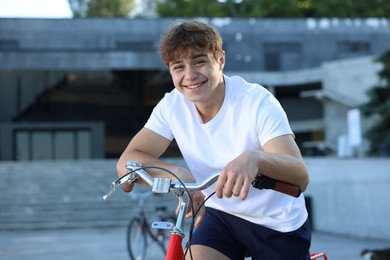 Photo of Teenage boy riding bicycle on city street