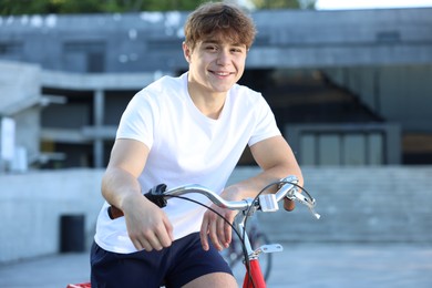 Photo of Teenage boy riding bicycle on city street