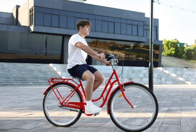 Photo of Teenage boy riding bicycle on city street
