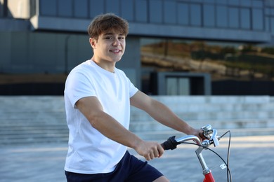 Photo of Teenage boy riding bicycle on city street