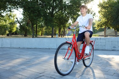 Photo of Teenage boy riding bicycle on city street, space for text