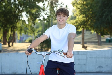 Photo of Teenage boy riding bicycle on city street