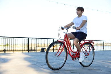 Photo of Teenage boy riding bicycle on city street, space for text