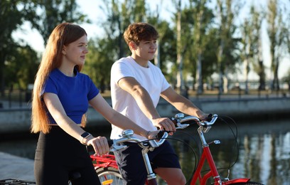 Photo of Teenage girl and boy riding bicycles on city street