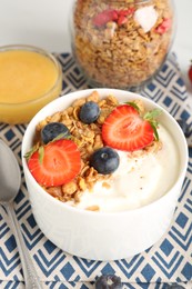 Photo of Tasty yogurt with granola, berries and honey on table, above view