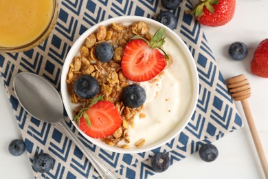 Photo of Tasty yogurt with granola, berries and honey on white table, flat lay