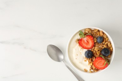 Photo of Tasty yogurt with granola, berries and spoon on white marble table, flat lay. Space for text