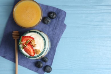 Photo of Tasty yogurt with granola, berries and honey on light blue wooden table, flat lay. Space for text