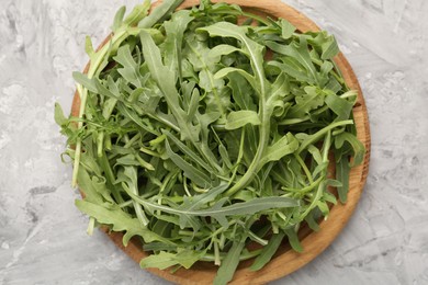 Photo of Fresh ripe green arugula leaves on grey table, top view