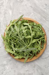 Photo of Fresh ripe green arugula leaves on grey table, top view