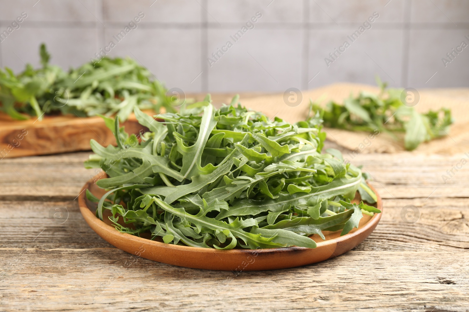 Fresh ripe green arugula leaves on wooden table, closeup Photo of Fresh ripe green arugula leaves on wooden table, closeup