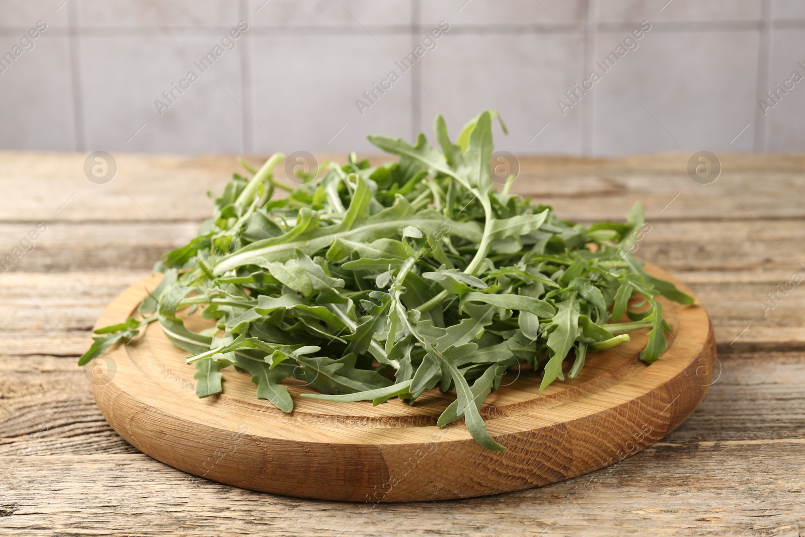 Fresh ripe green arugula leaves on wooden table, closeup Photo of Fresh ripe green arugula leaves on wooden table, closeup