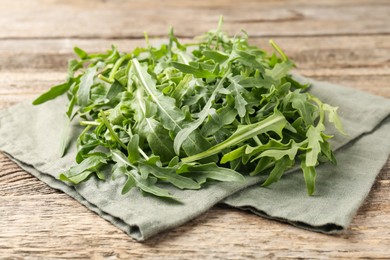 Photo of Fresh ripe green arugula leaves on wooden table, closeup