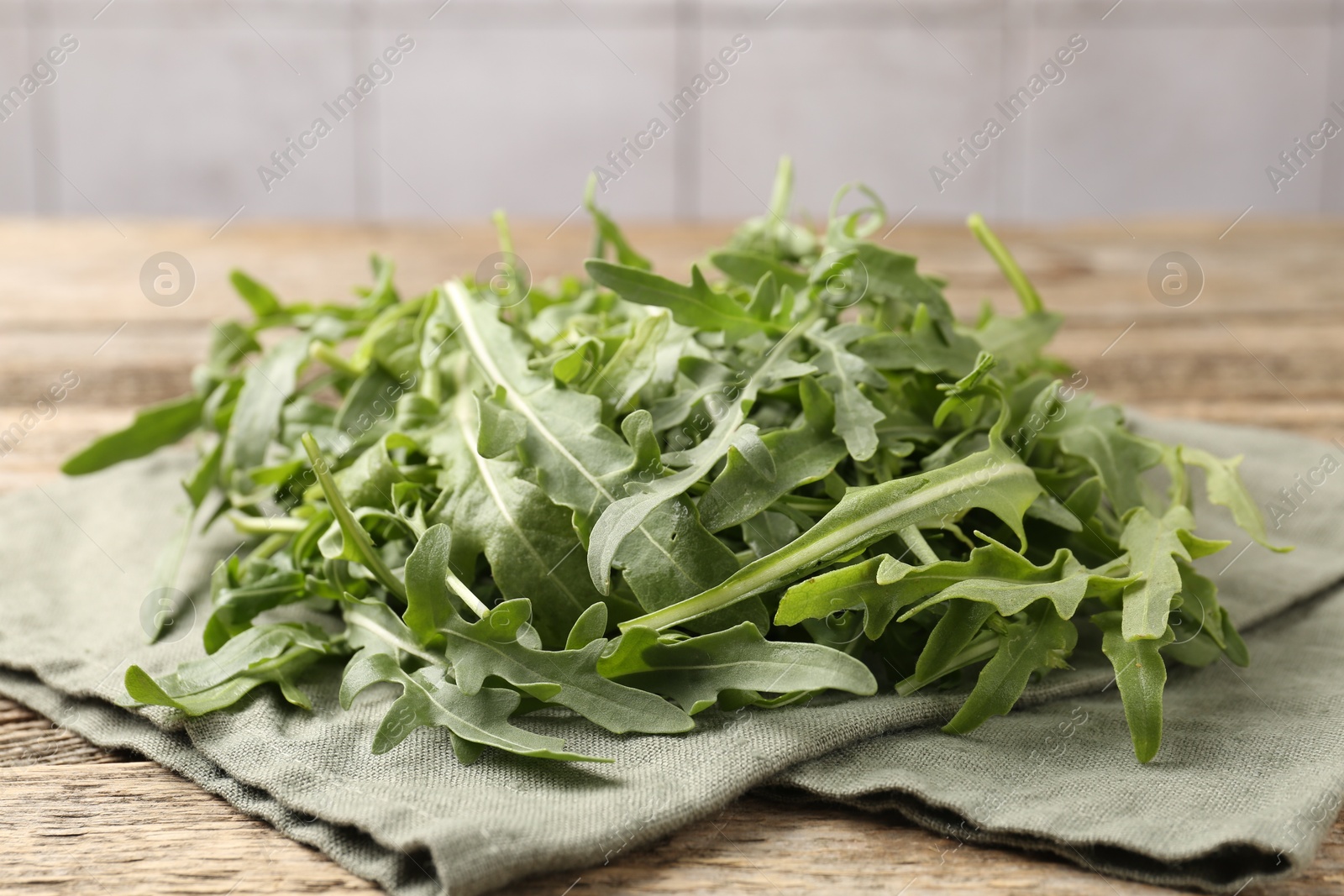 Fresh ripe green arugula leaves on wooden table, closeup Photo of Fresh ripe green arugula leaves on wooden table, closeup