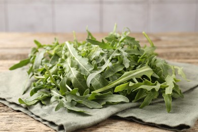 Photo of Fresh ripe green arugula leaves on wooden table, closeup