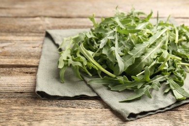 Photo of Fresh ripe green arugula leaves on wooden table, closeup. Space for text