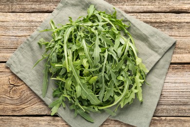Photo of Fresh ripe green arugula leaves on wooden table, top view